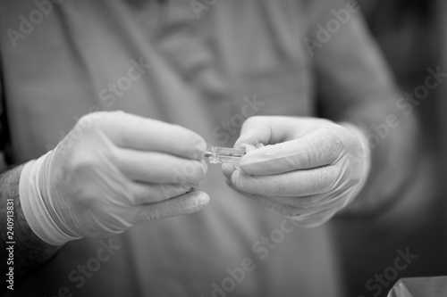 Dentist doctor hands in protective latex gloves with a special dental tool close-up
