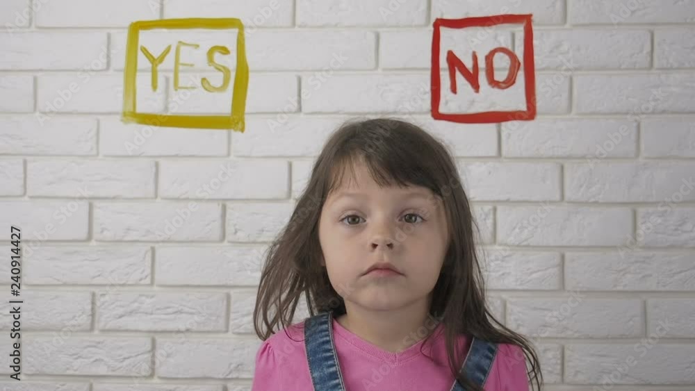 The child before the choice of yes or no. A cute little girl makes a choice between yes or no. The child before the choice of yes or no. A cute little girl makes a choice between yes or no.