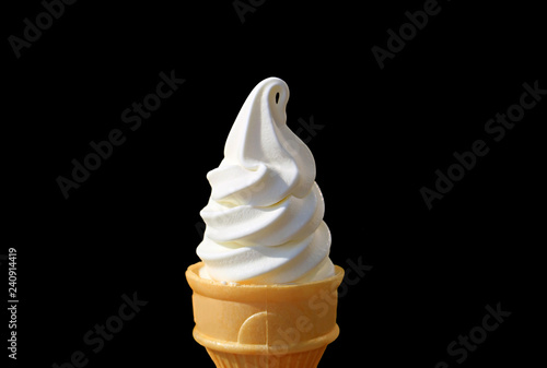 Mouthwatering Spiral Shaped Vanilla Soft Serve Ice Cream Cone Isolated on Black Background  photo