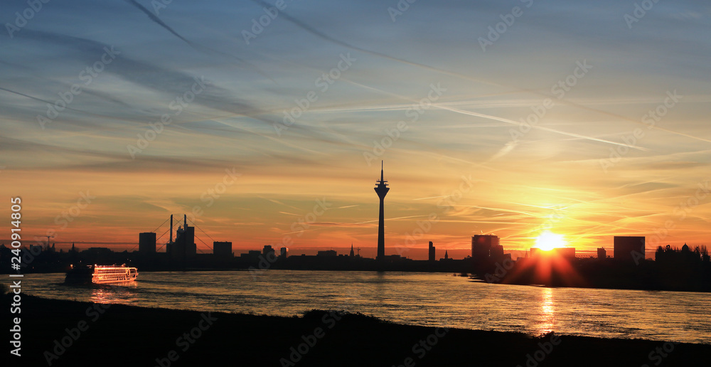 Düsseldorf am Rhein bei Sonnenaufgang, stimmungsvoll mit Rheinturm und Kreuzfahrtschiff