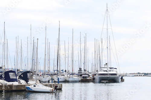 Panorama of a yacht marina in the town of Jezera in Croatia in the Dalmatia region. The ships moored in the port of a quiet fishing town in a sunny, clear day.
