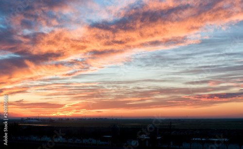 A calm soft orange sunset with atmospheric clouds.