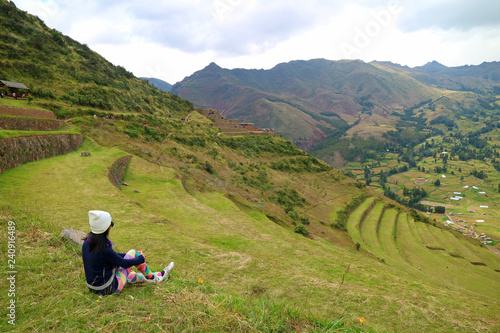 A Female Traveler Sitting on the Ancient Inca Agricultural Terraces at Pisac Archaeological Complex, Sacred Valley, Cusco region, Peru photo