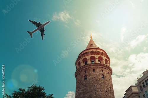 Airplane flies over the Galata tower, Istanbul, Turkey. Travel concept
