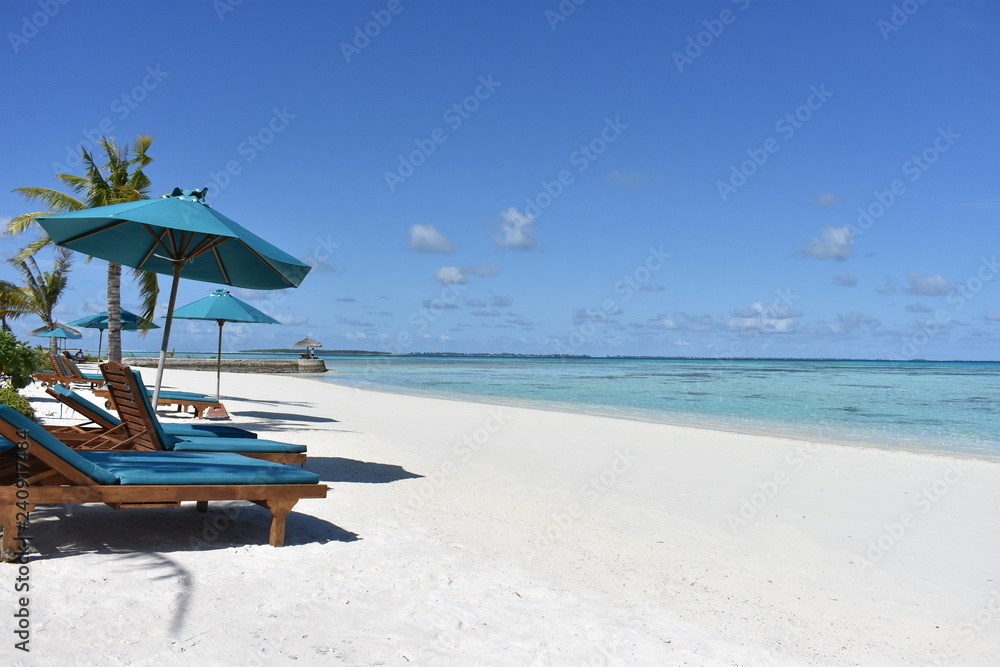 tropical beach with chairs and umbrellas