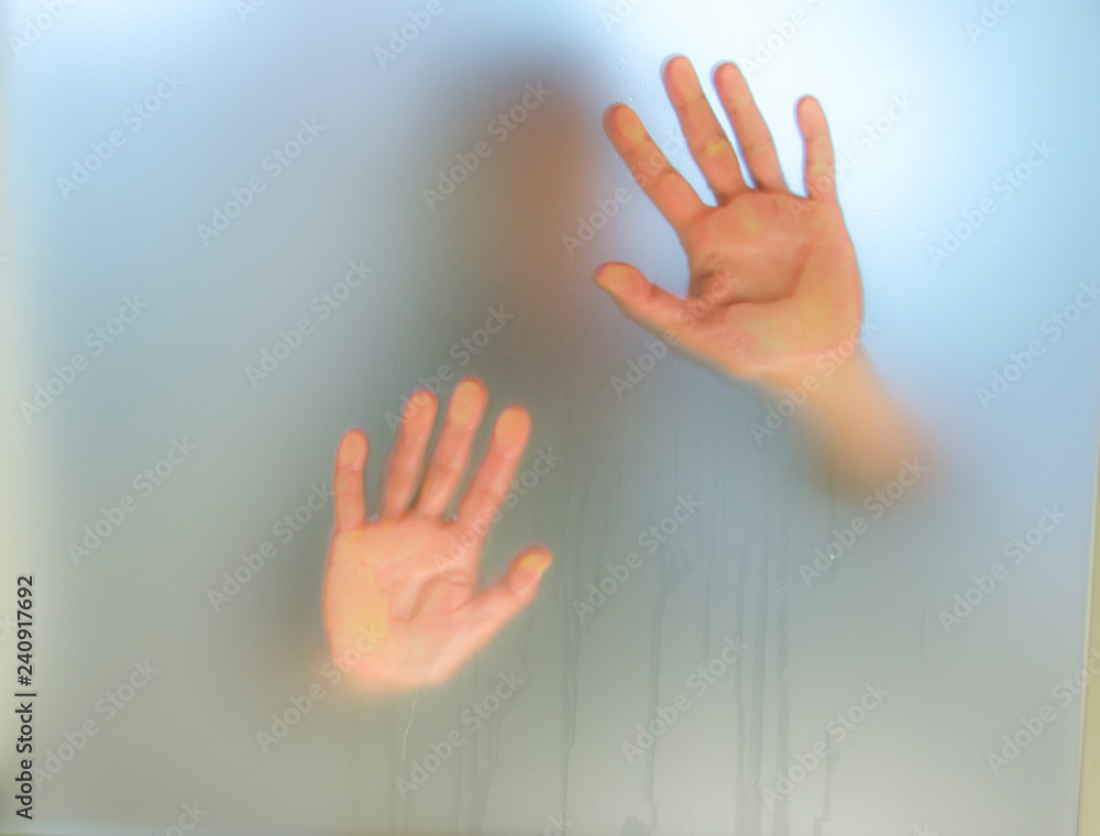 Human hands press against glass to get out Photos | Adobe Stock