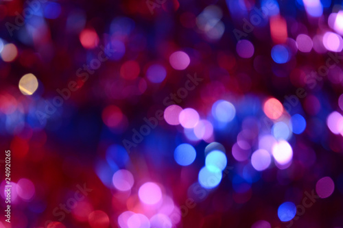 Bokeh. Holiday background. Christmas lights. Glitter. Defocused sparkles. New Year backdrop. Festive wallpaper. Blinks. Carnival. Bokeh retro style photo. Violet. Red. Blue.