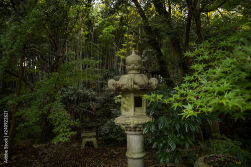 Fotografie Lanterne japonaise en pierre dans un jardin de Kyoto avec en arrière fond, un fo