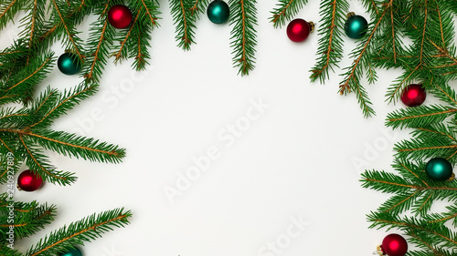 Branches of a Christmas tree border on one side on three sides with red and green balls on a white background, empty space, free space for text, insert