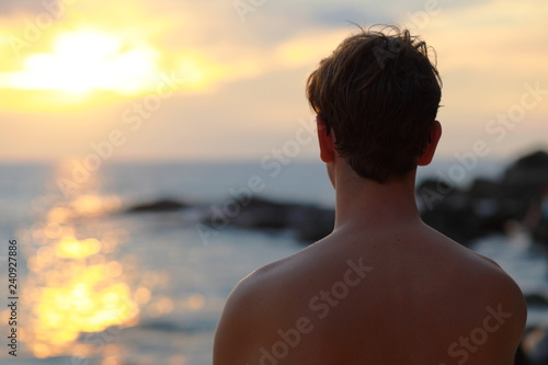 Man on the beach looking at sunset