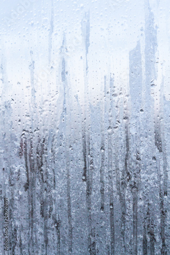 The frozen drops on the patterned frosty winter window © Viktoriya09