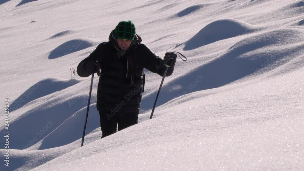 A lone tourist walks through the snow in a mountain forest. Traveler in the winter snowy forest. A young man with a backpack wanders through the snow-capped mountains. A lone tourist walks through the snow in a mountain forest. Traveler in the winter snowy forest. A young man with a backpack wanders through the snow-capped mountains.