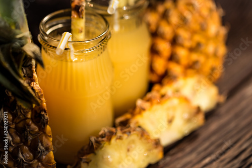 Pineapple juice and slice placed on a wooden table photo