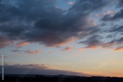mountain on sunset in blue and orange cloud sky background © Khathawuth
