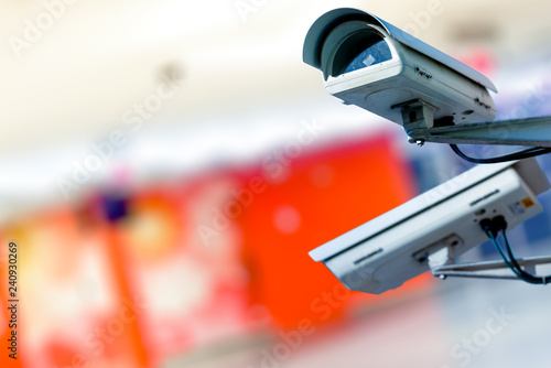 Modern CCTV camera on a wall. with blurred coloreful background.