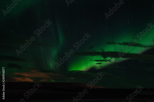 Winter scenic landscape night view of Aurora Borealis/Northern lights dancing on the clear sky full of stars above lake Myvatn, north Iceland Beautiful winter wonderland/fairytale background scene. 