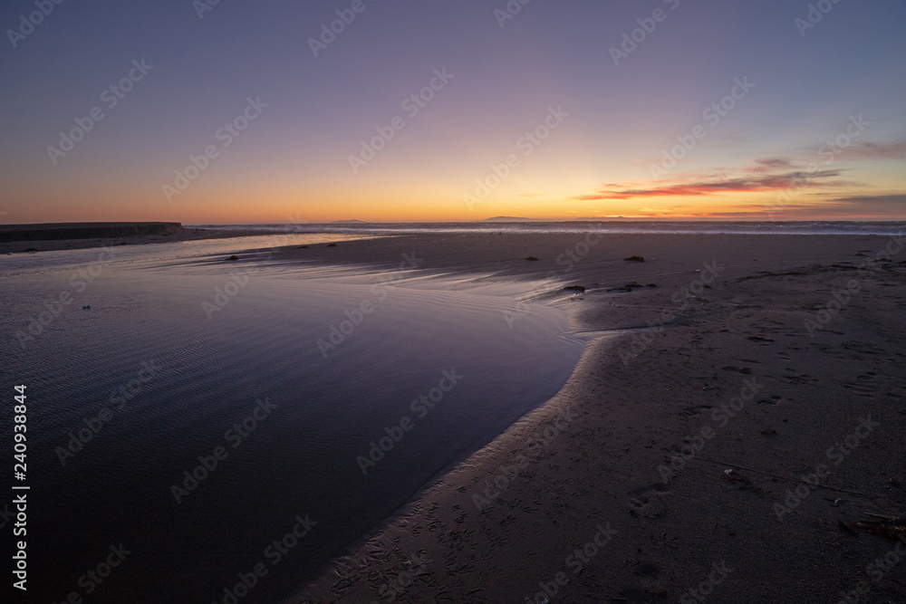 Sunset light reflections over Santa Clara River tidal outflow to Pacific Ocean at McGrath State Park on the California Gold Coast at Ventura - United States