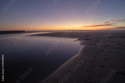 Sunset light reflections over Santa Clara River tidal outflow to Pacific Ocean at McGrath State Park on the California Gold Coast at Ventura - United States