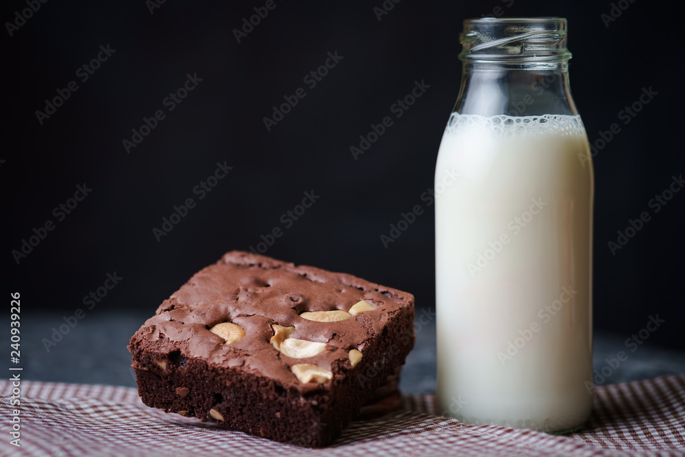 Brownies with bottle of milk on the black background Brownies with bottle of milk on the black background