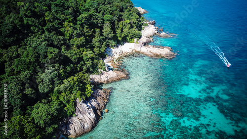 Amazing aerial drone view of a boat approaching Perhentian Island, a tropical paradise in Malaysia photo