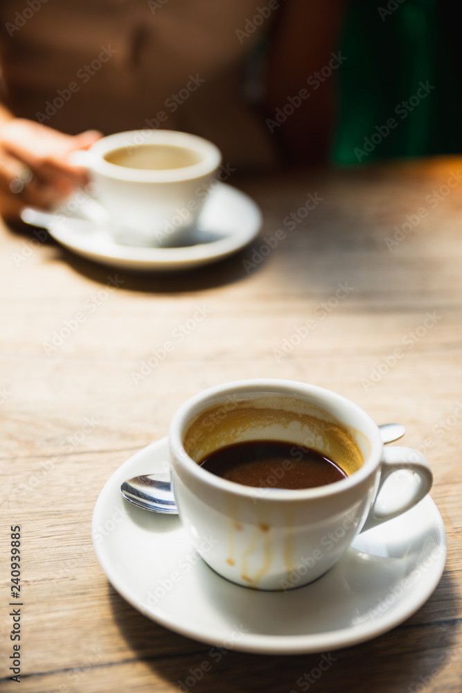 Dirty coffee cup on the wooden table with natural light in the cafe.