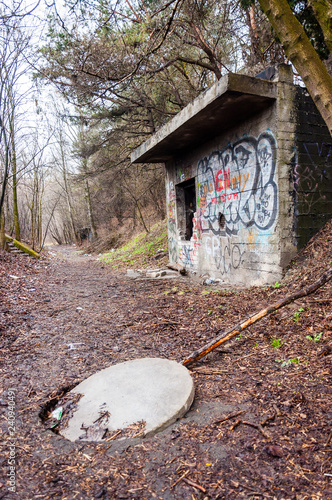 Open manhole on the ground on the way to abandoned concrete bunker built during the Second World War right in a hill near the center of Vilnius. photo