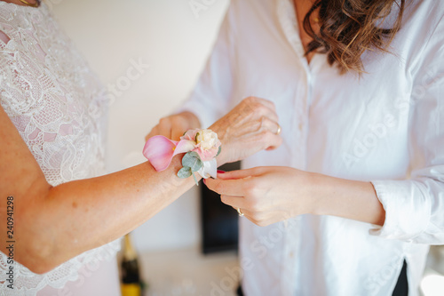 Wall Mural woman putting on wrist corsage for wedding