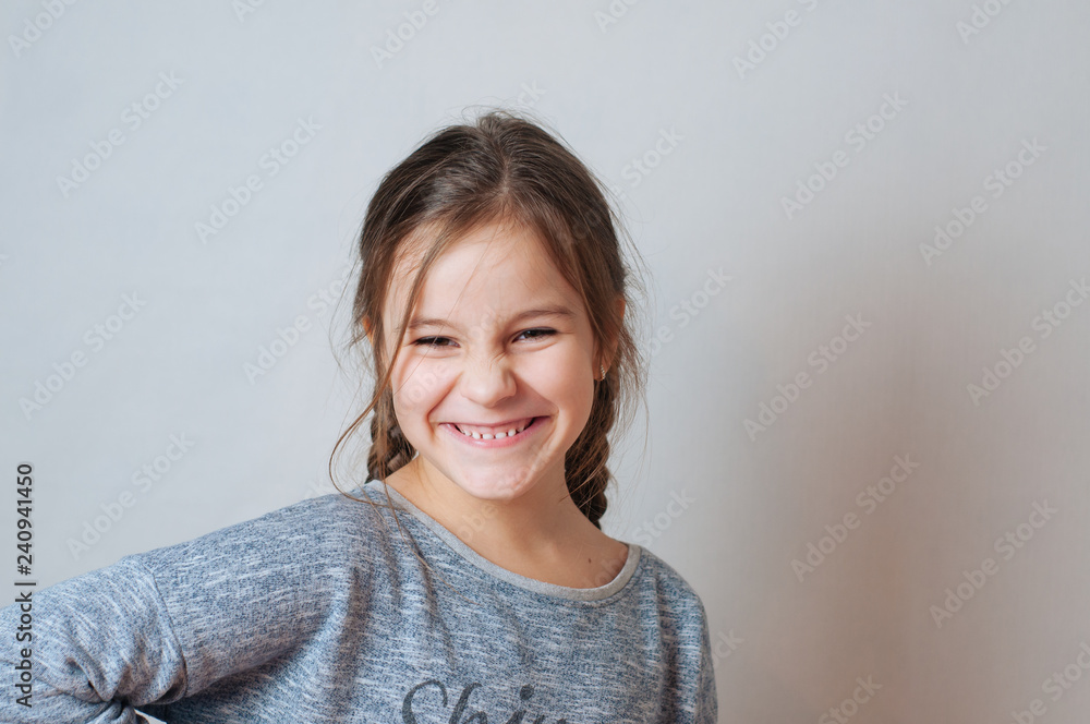 Funny little girl with pigtails in a gray jacket Funny little girl with pigtails in a gray jacket
