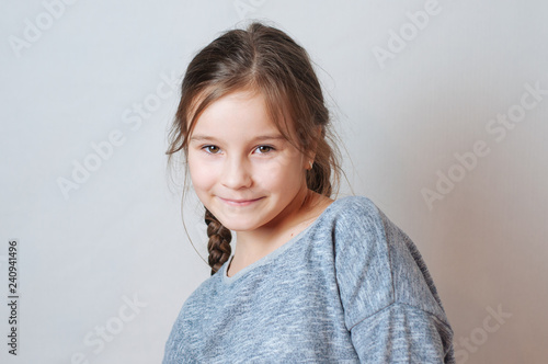 Funny little girl with pigtails in a gray jacket