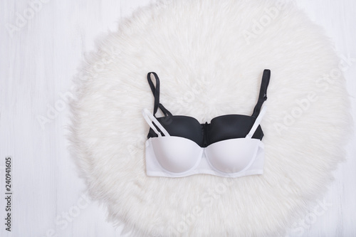 Black and white bra on white fur. Lingerie. Fashion concept