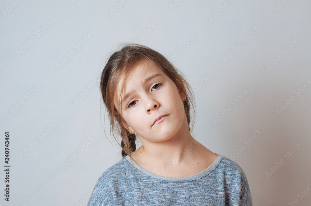 Sad little girl with pigtails portrait on a neutral background Sad little girl with pigtails portrait on a neutral background