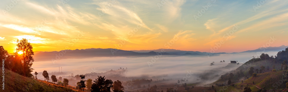 Obraz premium Mountain and foggy at morning time with orange sky, beautiful landscape in the thailand