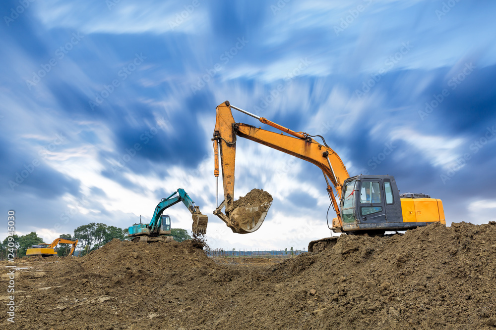 Obraz premium Excavator working on construction site in cloudy day