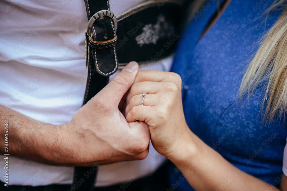 couple wearing traditional bavarian attire, engagement ring closeup