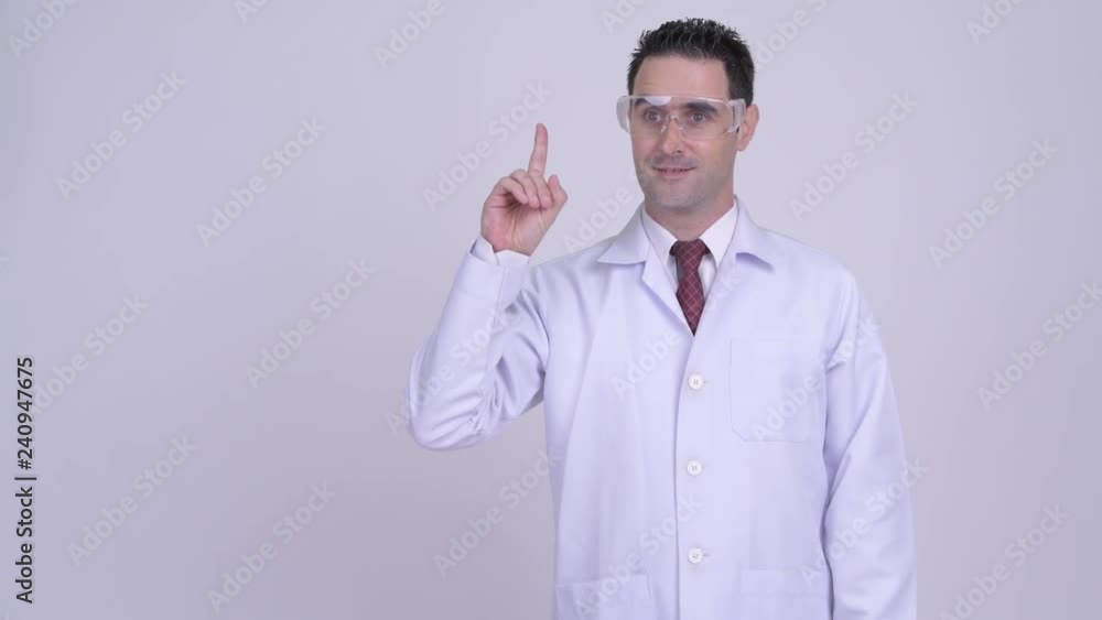 Happy handsome man doctor with protective glasses pointing up Happy handsome man doctor with protective glasses pointing up
