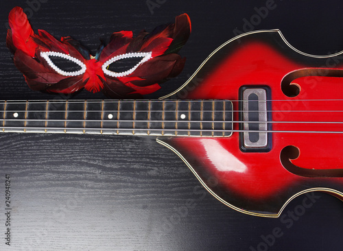 Bilde på lerret Electro bass guitar and carnival mask on a dark background