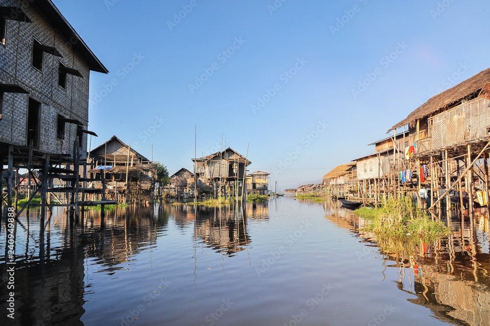 Bamboo houses on piles standing in water in township