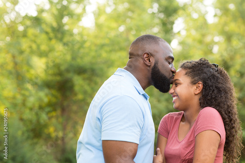 Father and his daughter laughing and playing at the park.