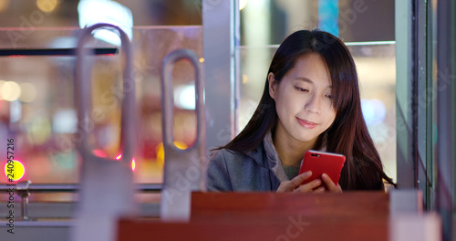 Canvas Print Woman use of mobile phone on tram at night