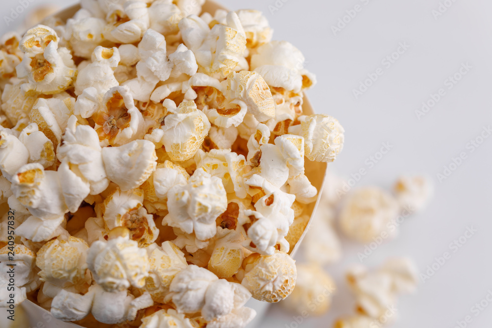 A paper bucket full of popcorn on a white background. Top view.