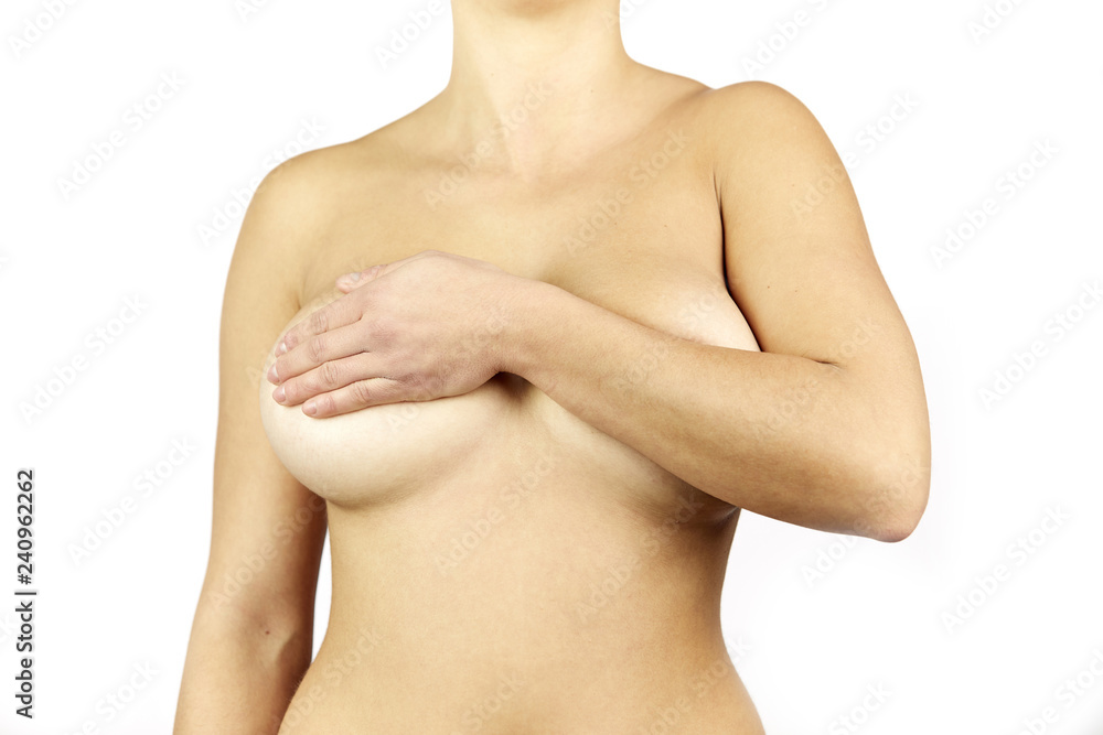 Young adult naked woman examining her breast for lumps or signs of breast cancer Young adult naked woman examining her breast for lumps or signs of breast cancer