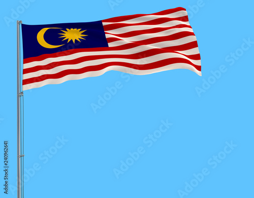 Isolate flag of Malaysia on a flagpole fluttering in the wind on a blue background, 3d rendering. photo