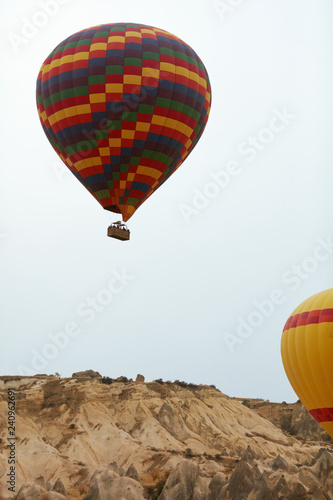 Colorful Hot Air Balloon With Basket Flying In Sky Above Land