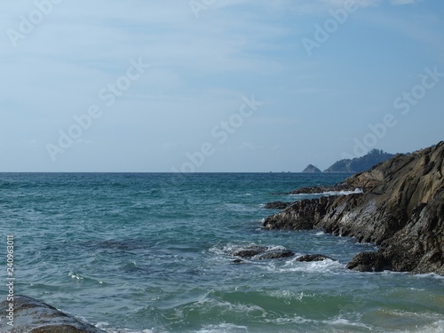 Sea and rocks. Sea waves beating on stones on the coast. Scenic views of the open ocean. Panorama of the horizon, sea and rocky shore on a clear sunny day. Seascape of water and mountains.