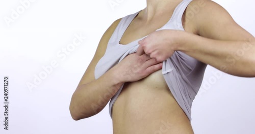 Woman white shirt examining her breast for lumps or signs of breast cancer side view photo