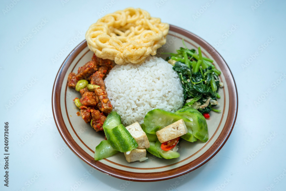 Indonesian home made style food nasi campur or mixed rice with krupuk, tempe balado, pete, sayur bayam, tahu dan sayur oyong Indonesian home made style food nasi campur or mixed rice with krupuk, tempe balado, pete, sayur bayam, tahu dan sayur oyong