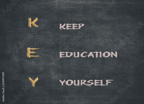KEY acronym - KEEP EDUCATING YOURSELF. Educational concept with different color sticky notes and white chalk handwriting on a blackboard