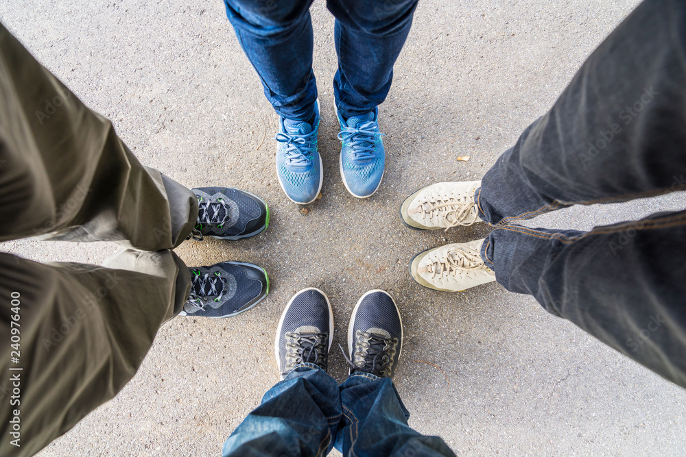 Group of four persons standing together in a circle as a team