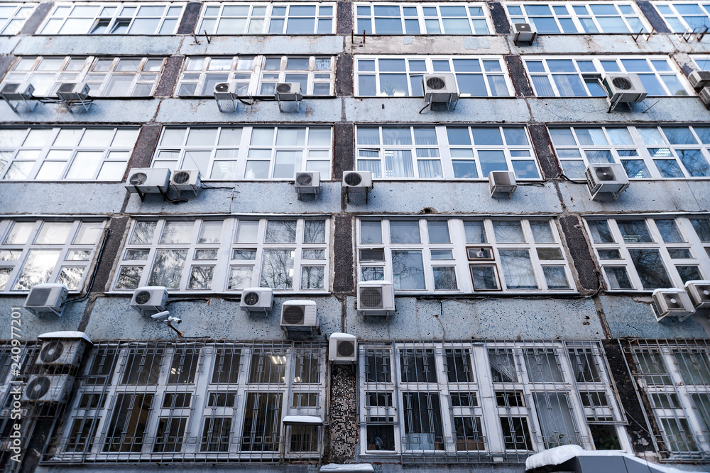 The facade of the building with large Windows and lots of air conditioning The facade of the building with large Windows and lots of air conditioning