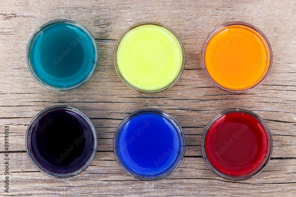 Water colors of aquamarine, yellow, red, violet, blue and orange color on a wooden surface. View from above. Close-up. Water colors of aquamarine, yellow, red, violet, blue and orange color on a wooden surface. View from above. Close-up.